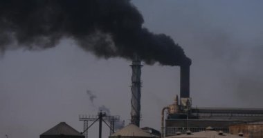 Mısır 'ın güneyindeki Nil Nehri kıyısında bulunan şeker rafinerisinin bacalarından duman yükseliyor..