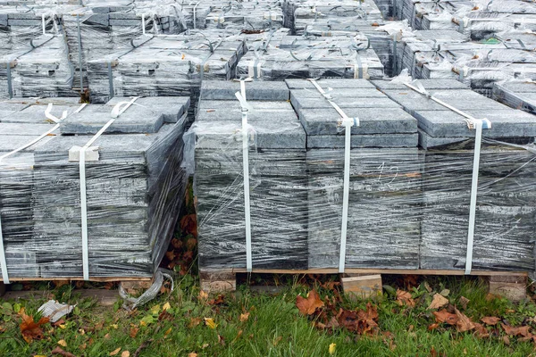 stock image Many of the outdoor paving slabs on the construction site are stacked on pallets in the meadow in autumn