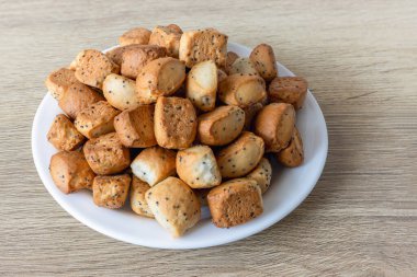 Kuciukai - traditional Lithuanian Christmas cookies with poppy seeds or chips on a plate on an oak table surface clipart