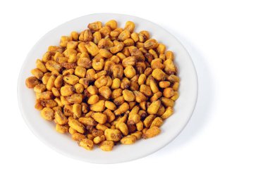 Beyaz zemin üzerinde bir tabakta kavrulmuş tuzlu mısır izole edilmiş üst manzara