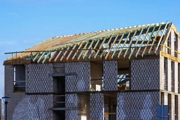 Ready-made wooden roof frame structures of a building against a blue sky background