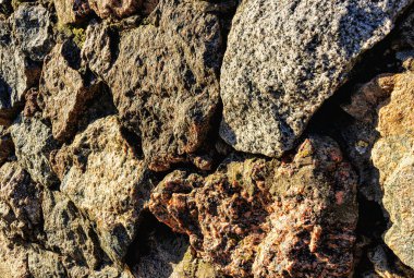 A wall of stones of various sizes and shapes as a background close-up