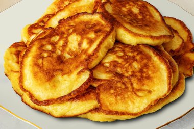 A stack of golden pancakes from yeast sourdough on a plate, close up