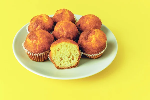 mini muffins, cupcakes with paper on a plate on a yellow background
