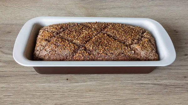 Loaf Dark Rye Bread Sesame Seeds Baking Pan Oak Table — Stock Photo, Image