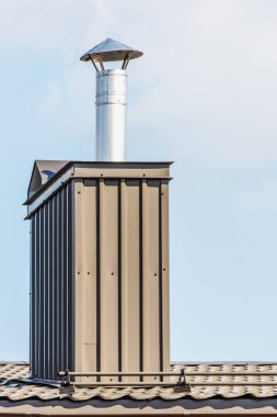 Gökyüzü arka planına yuvarlak paslanmaz metal eklenmiş ev bacası