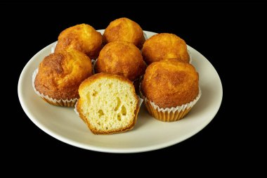 Mini kekler, tabakta kapkekler, siyah arka planda izole edilmiş.