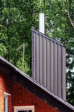 Konserve tuğla ev bacası. Çatıya metal eklenmiş. Televizyon anteni de var.