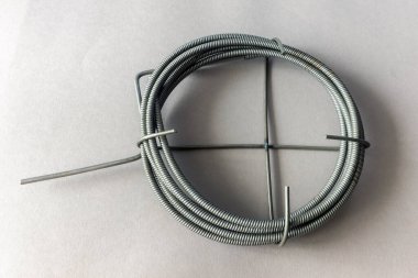 Gri arkaplandaki kanalizasyon borularını temizlemek için boyanmış metal kabloların üst görünümü