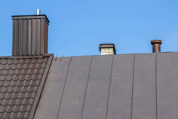 スカイバックグラウンドのスズ屋根に丸いステンレスメタルインサートの家のキムニー — ストック写真