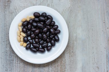 Tahta bir yüzey üzerinde beyaz bir tabakta kakaolu yerfıstığı, üst manzara.