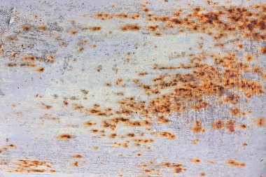 Pas ve soyulan boya metal bir borunun yüzeyini kaplıyor, zamanla aşınmış katmanlar sergiliyor. Değişen dokular elementlere ve yaşa maruz kalmanın etkilerini vurgular.