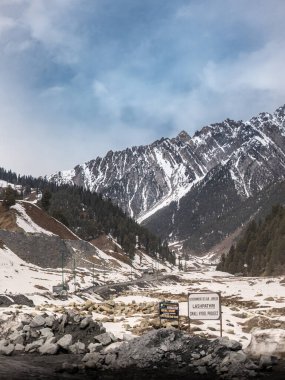 Kashmir 'de karla kaplı ağaçlar ve dağlarla kaplı güzel kış manzarası.