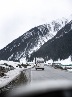 Kashmir 'de karla kaplı ağaçlar ve dağlarla kaplı güzel kış manzarası.