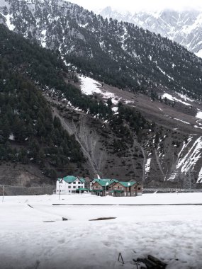 Kashmir 'de karla kaplı ağaçlar ve dağlarla kaplı güzel kış manzarası.