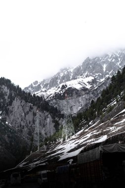 Kashmir 'de karla kaplı ağaçlar ve dağlarla kaplı güzel kış manzarası.