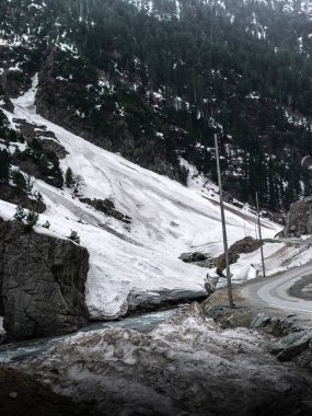 Kashmir 'de karla kaplı ağaçlar ve dağlarla kaplı güzel kış manzarası.