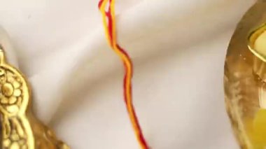 Raksha Bandhan, ahşap desenli arka planda zarif Rakhi ve pirinç taneleri ile donatılmış..