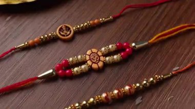 Raksha Bandhan, ahşap desenli arka planda zarif Rakhi ve pirinç taneleri ile donatılmış..
