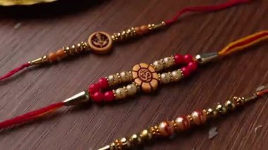 Raksha Bandhan, ahşap desenli arka planda zarif Rakhi ve pirinç taneleri ile donatılmış..