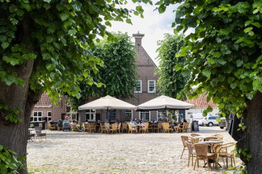 BOURTANGE, NETHERLANDS, 30 Haziran 2023: Fort Bourtange 'ın merkezindeki ana pazar meydanı ve sokak kafeleri. Eski yıldız kalesi Hollanda 'nın Groningen bölgesinde popüler bir turizm merkezidir.. 