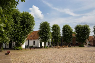 Fort Bourtange 'ın merkezindeki ana pazar meydanı ve sokak kafeleri. Eski yıldız kalesi Hollanda 'nın Groningen bölgesinde popüler bir turizm merkezidir. Boşluğu sağ üstte kopyala.