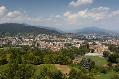 İtalya 'nın Lombardy kentindeki eski kentin (Citta Alta) şehir duvarlarından yeni Bergamo (Citta Bassa) kentinin havadan yaz manzarası. Yukarıdaki alanı kopyala.