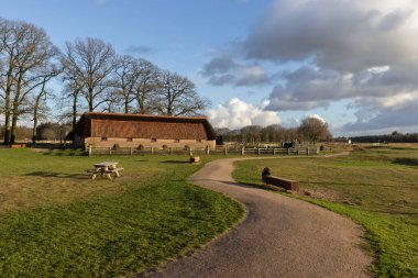 Hollanda, Gelderland yakınlarındaki Ginkel Heath 'de güneşli bir kış gününde koyun ağılı ve patika. Burası Heathland Doğa Koruma Alanındaki birçok yürüyüşün başlangıç noktasıdır..