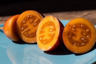 Dilimlenmiş Tamarillo meyvesinin (Solanum betaceum) yakın görüntüsü. Güney Amerika And Dağları 'nın yerlisi yumurta şeklindeki yenilebilir meyve aynı zamanda ağaç domatesi ya da domates de arbol olarak bilinir..