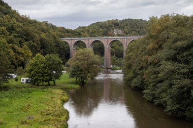 Belçika 'nın Ardennes Bölgesi' ndeki Herbeumont yakınlarındaki Semois Nehri 'ni geçen 19. yüzyılın sonbahar manzarası 40 metre yüksekliğindeki Conques Viaduct. Boşluğu aşağıya kopyala.
