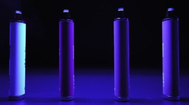 Neon Lighting ve Smoke 'ta bir sürü e-sigara ve Vapes var. Kötü alışkanlık kavramı. Modern Tütün Ürünleri Alternatifi. Nikotin Bağımlılığı. Yavaş Hareket.