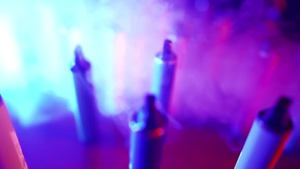 霓虹灯和烟雾中大量的电子香烟和录音带 恶习的概念 烟草产品的现代替代品 尼古丁成瘾 慢动作 — 图库视频影像