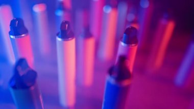 Neon Lighting ve Smoke 'ta bir sürü e-sigara ve Vapes var. Kötü alışkanlık kavramı. Modern Tütün Ürünleri Alternatifi. Nikotin Bağımlılığı. Yavaş Hareket.