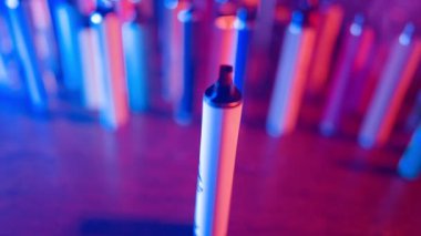 Neon Lighting ve Smoke 'ta bir sürü e-sigara ve Vapes var. Kötü alışkanlık kavramı. Modern Tütün Ürünleri Alternatifi. Nikotin Bağımlılığı. Yavaş Hareket.