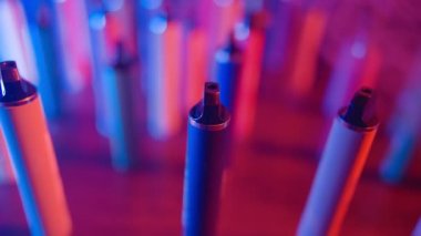 Neon Lighting ve Smoke 'ta bir sürü e-sigara ve Vapes var. Kötü alışkanlık kavramı. Modern Tütün Ürünleri Alternatifi. Nikotin Bağımlılığı. Yavaş Hareket.