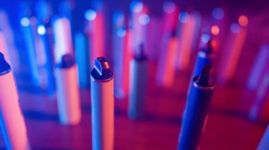 Neon Lighting ve Smoke 'ta bir sürü e-sigara ve Vapes var. Kötü alışkanlık kavramı. Modern Tütün Ürünleri Alternatifi. Nikotin Bağımlılığı. Yavaş Hareket.