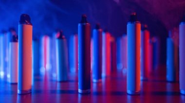 Neon Lighting ve Smoke 'ta bir sürü e-sigara ve Vapes var. Kötü alışkanlık kavramı. Modern Tütün Ürünleri Alternatifi. Nikotin Bağımlılığı. Yavaş Hareket.