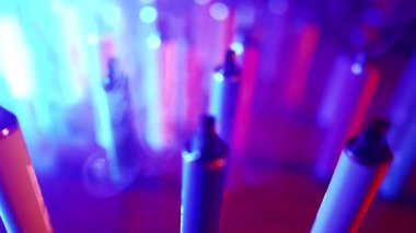Neon Lighting ve Smoke 'ta bir sürü e-sigara ve Vapes var. Kötü alışkanlık kavramı. Modern Tütün Ürünleri Alternatifi. Nikotin Bağımlılığı. Yavaş Hareket.