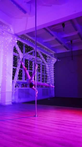 アスレチック女性はネオン照明でパイロン上の美しいダンス番号を実行します スローモーションでポールダンス — ストック動画