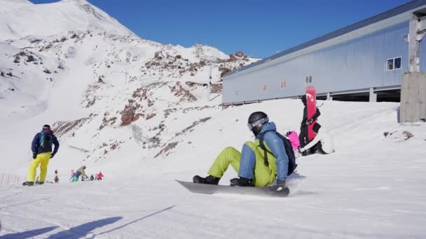 エルブラス ロシア 2023年2月25日 スノーボーダーが落ち スキーリゾートでスキーが過ぎ去ります スローモーション — ストック動画