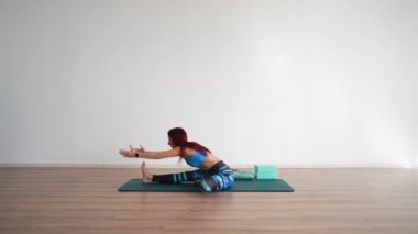 Athletic Woman Trainer Leads an Online Stretching Workout on a White Background. Online Learning Concept and E-learning. 