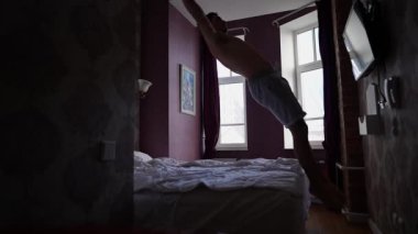 Şortlu Adam Bir Ortopedik Yatakla Yatağa Atlıyor. Adam otel odasında eğleniyor, kanepeye zıplıyor. Süper Yavaş Hareket.