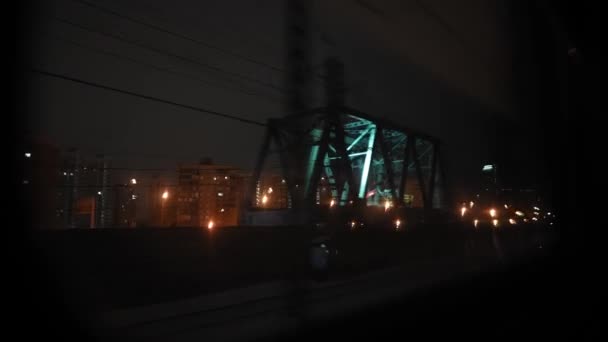 夜には鉄道の移動列車の窓からの眺め 旅行や観光の概念 町の外に出る旅客列車 — ストック動画