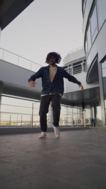 Dikey Video, Şık Sokak Dansçısı Şehir Arkaplanında Hip Hop ve Breakdance. Moda Giyimli Modern Adam Şehir Caddesinde Dans Ediyor. Yavaş Hareket.