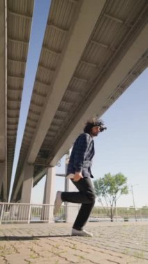 Dikey Video, Modern Adam Şehir Caddesinde Dans Ediyor. Güneşli bir günde modern koreografiyle dans eden modacı. Yavaş Hareket.
