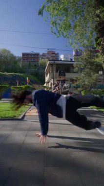Dikey Video, Şık Sokak Dansçısı Şehir Arkaplanında Hip Hop ve Breakdance. Moda Giyimli Modern Adam Şehir Caddesinde Dans Ediyor. Yavaş Hareket.
