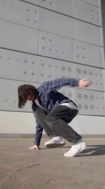 Dikey Video, Şık Sokak Dansçısı Şehir Arkaplanında Hip Hop ve Breakdance. Moda Giyimli Modern Adam Şehir Caddesinde Dans Ediyor. Yavaş Hareket.