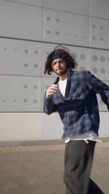 Dikey Video, Şık Sokak Dansçısı Şehir Arkaplanında Hip Hop ve Breakdance. Moda Giyimli Modern Adam Şehir Caddesinde Dans Ediyor. Yavaş Hareket.