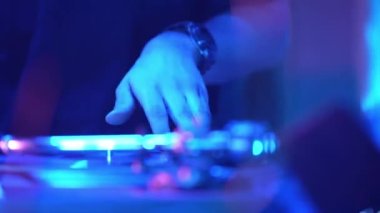 DJ, gece kulübü partisinde DJ konsolunda şarkı karıştırıyor. Gece kulübü disko partisinde DJ Mixer Controller masası. Eller düğmelere basıyor ve sürgüler Elektronik Müzik Çalıyor