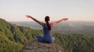 Kadın Sporcu Yoga Antrenmanı. Güneş doğarken dağlarda yoga yapan sağlıklı bir kadın. Refah ve Sağlıklı Yaşam Tarzı, Zen Kavramı. Yavaş Hareket.